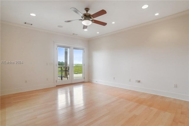 spare room featuring crown molding and light hardwood / wood-style floors