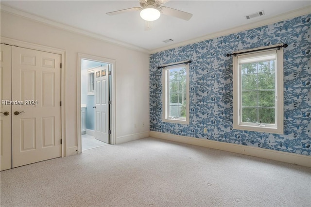 unfurnished room with light carpet, crown molding, and plenty of natural light