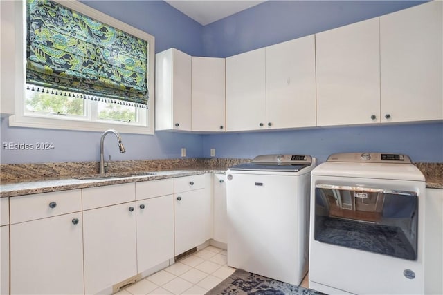 washroom with cabinets, light tile patterned flooring, sink, and washing machine and clothes dryer