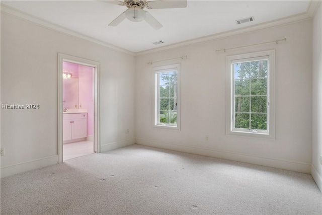 unfurnished room featuring ornamental molding, a wealth of natural light, light colored carpet, and ceiling fan