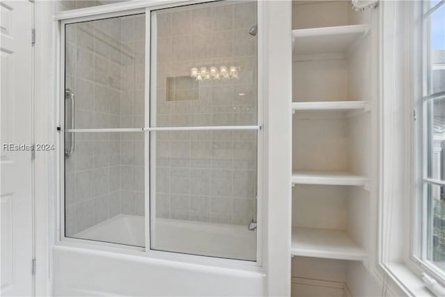 bathroom featuring bath / shower combo with glass door and built in features