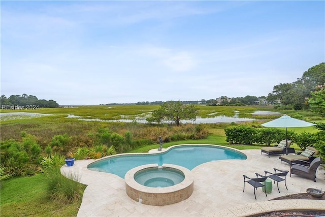 view of swimming pool with an in ground hot tub, a water view, and a patio