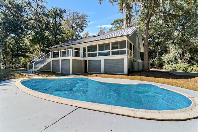 view of swimming pool featuring a sunroom