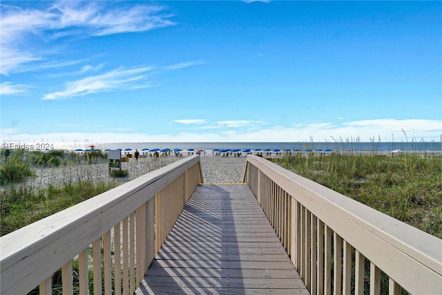 view of community featuring a water view and a beach view