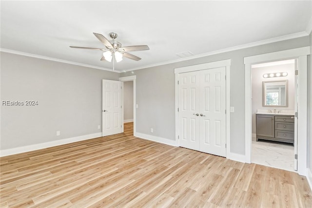 unfurnished bedroom featuring ceiling fan, ensuite bath, and crown molding