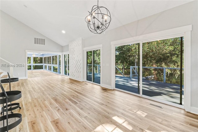 interior space featuring high vaulted ceiling, a notable chandelier, and light hardwood / wood-style floors