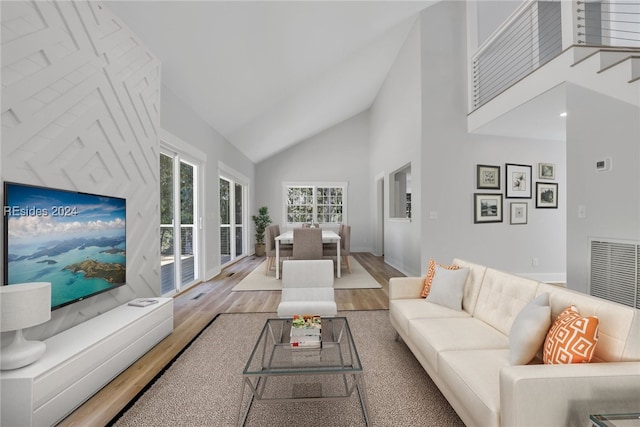 living room with wood-type flooring and high vaulted ceiling