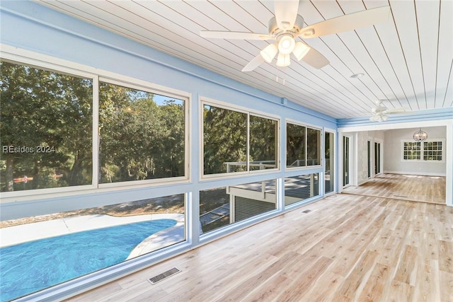 unfurnished sunroom with wood ceiling and ceiling fan