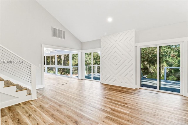 unfurnished living room with high vaulted ceiling and light hardwood / wood-style flooring