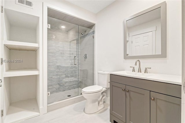 bathroom with a shower with door, vanity, and toilet