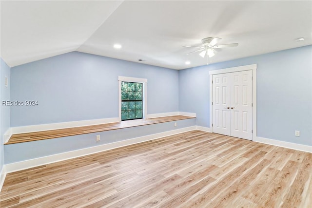 spare room featuring ceiling fan, lofted ceiling, and light hardwood / wood-style floors