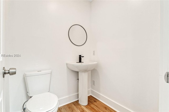 bathroom featuring hardwood / wood-style flooring, sink, and toilet