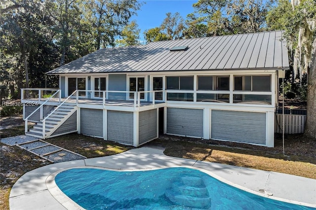 back of property featuring a sunroom and a swimming pool side deck