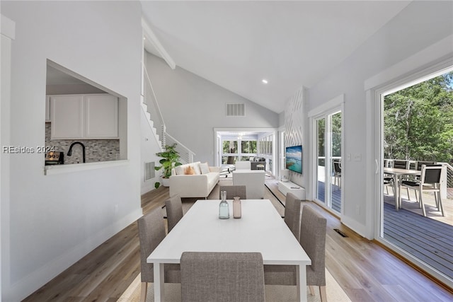 dining room featuring vaulted ceiling and light wood-type flooring