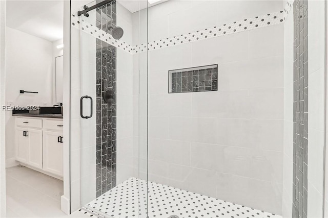 bathroom with an enclosed shower, vanity, and tile patterned floors