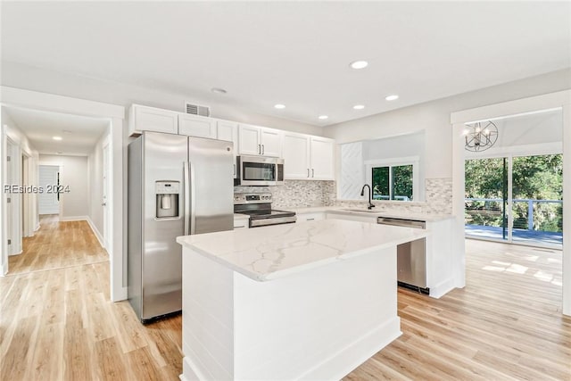 kitchen featuring appliances with stainless steel finishes, sink, light hardwood / wood-style flooring, and white cabinets