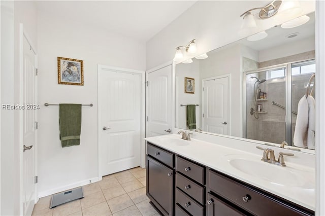 bathroom featuring a shower with door, vanity, and tile patterned floors