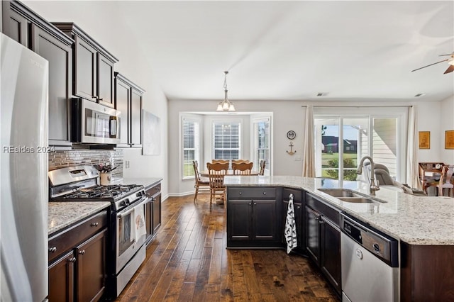 kitchen featuring decorative light fixtures, sink, dark hardwood / wood-style flooring, dark brown cabinetry, and stainless steel appliances