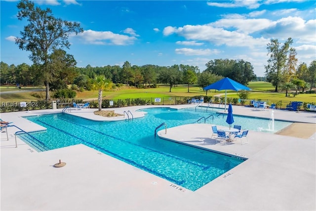 view of swimming pool featuring a yard, a patio, and pool water feature