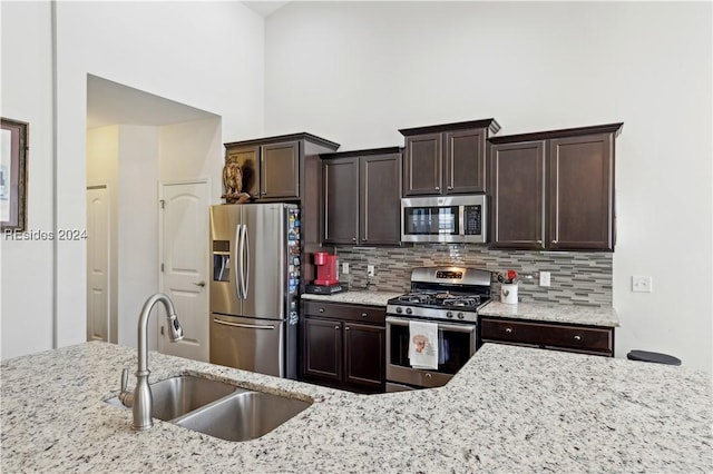 kitchen featuring tasteful backsplash, appliances with stainless steel finishes, sink, and dark brown cabinets