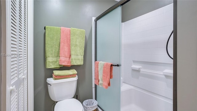 bathroom featuring toilet and a shower with door