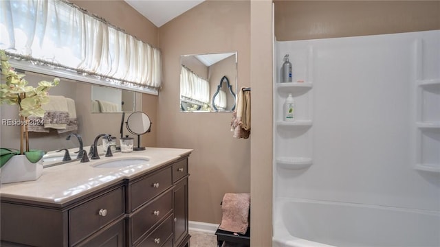 bathroom featuring lofted ceiling, vanity, and tub / shower combination