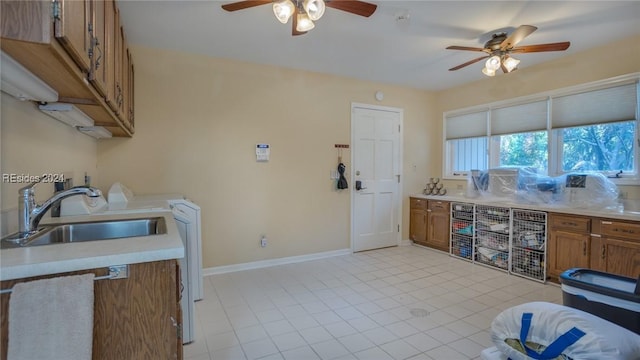 kitchen with sink, washer / dryer, and ceiling fan