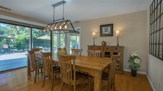 dining space with wood-type flooring