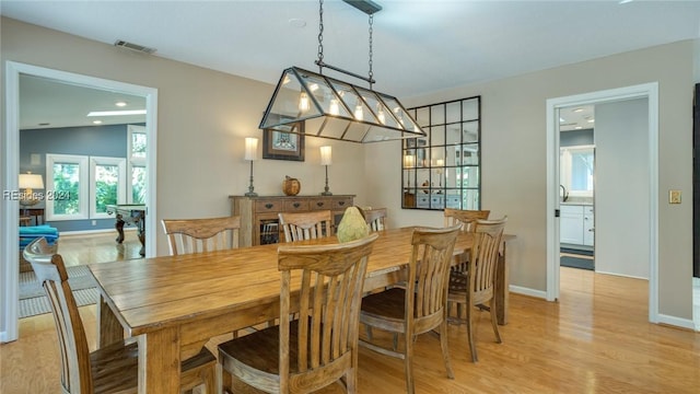 dining area featuring vaulted ceiling and light hardwood / wood-style floors