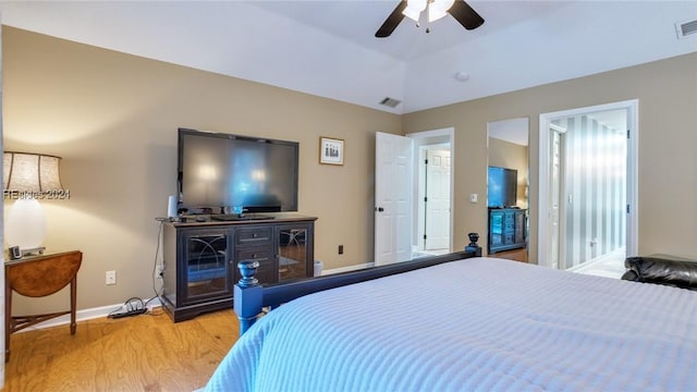 bedroom featuring hardwood / wood-style floors, vaulted ceiling, and ceiling fan