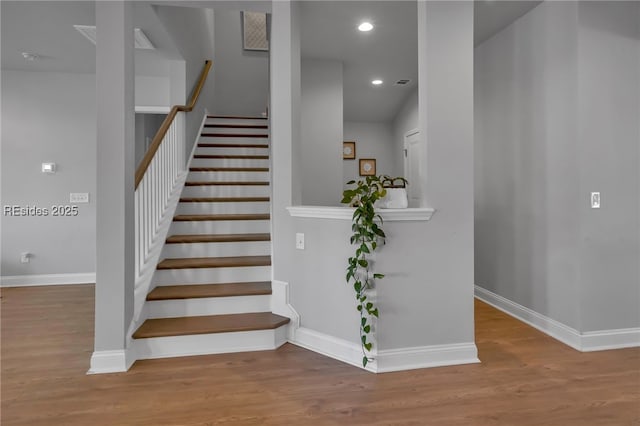 stairs featuring hardwood / wood-style floors