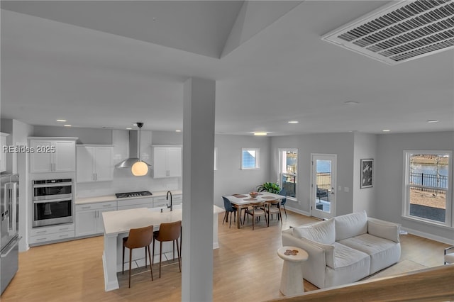 living room with sink and light hardwood / wood-style floors