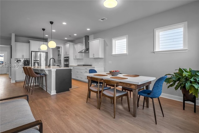 dining room with sink and light hardwood / wood-style flooring