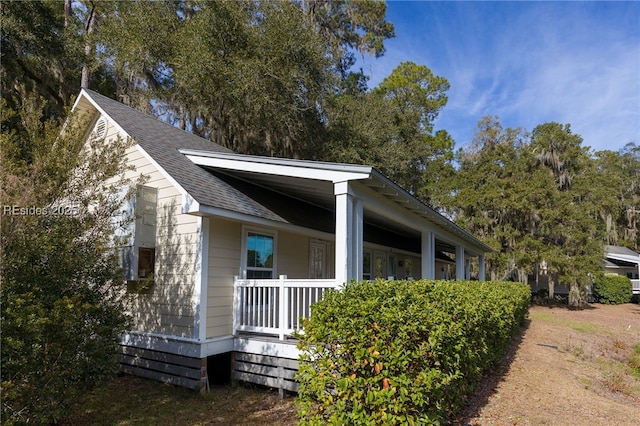 view of side of home featuring covered porch