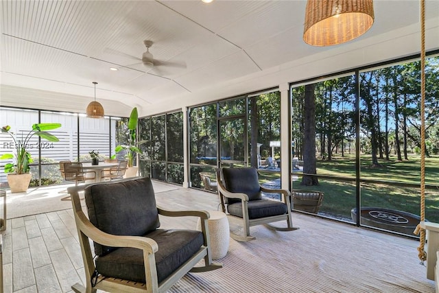 sunroom / solarium with ceiling fan, vaulted ceiling, and a wealth of natural light