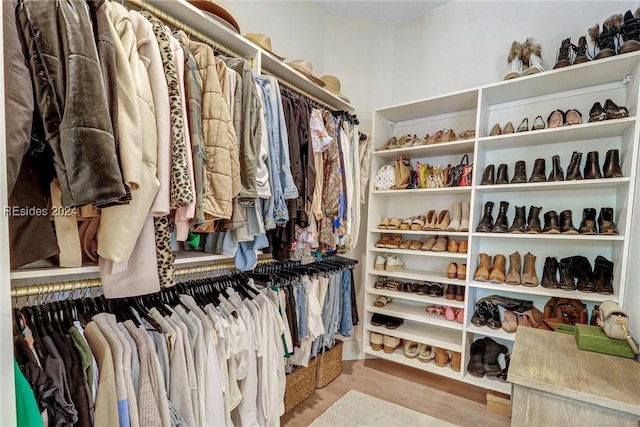 walk in closet with light hardwood / wood-style floors