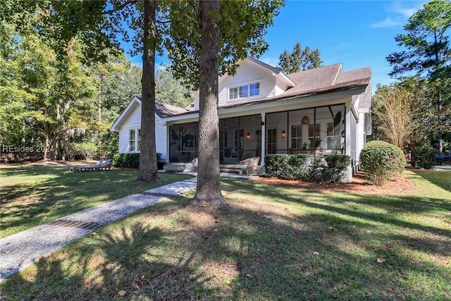 rear view of property featuring a sunroom and a lawn