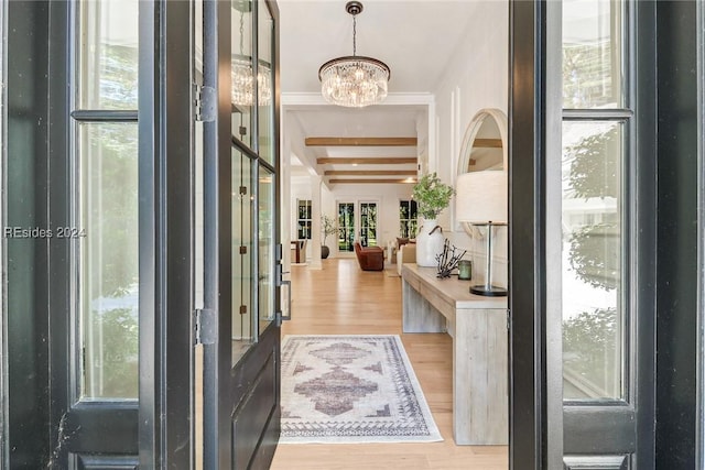 foyer entrance featuring an inviting chandelier, hardwood / wood-style floors, and beam ceiling