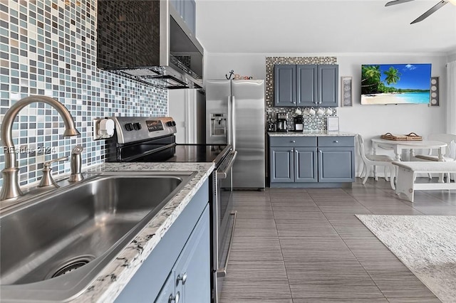 kitchen with light tile patterned flooring, appliances with stainless steel finishes, tasteful backsplash, sink, and ceiling fan