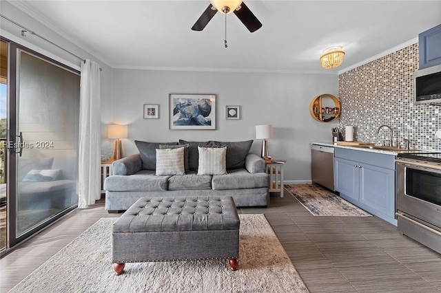 living room featuring ceiling fan, ornamental molding, and sink