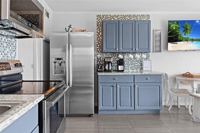 kitchen with light tile patterned floors, crown molding, stainless steel appliances, light stone counters, and decorative backsplash