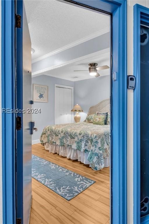 bedroom with crown molding, ceiling fan, a textured ceiling, and hardwood / wood-style flooring