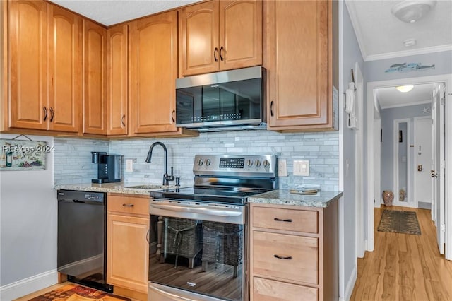 kitchen with appliances with stainless steel finishes, tasteful backsplash, sink, light stone counters, and crown molding