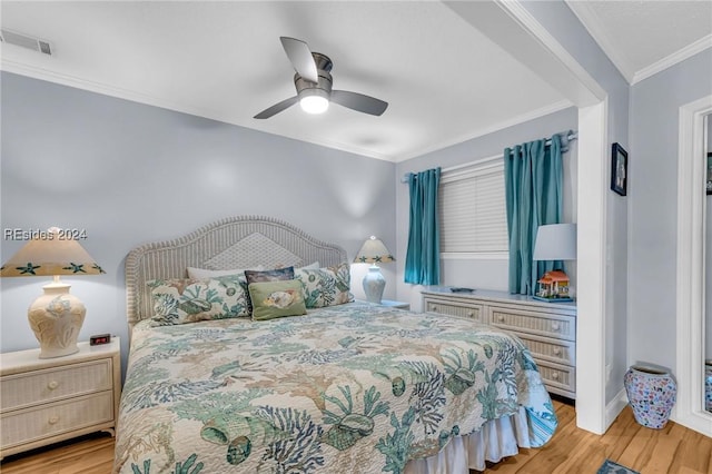 bedroom featuring ornamental molding, light hardwood / wood-style floors, and ceiling fan