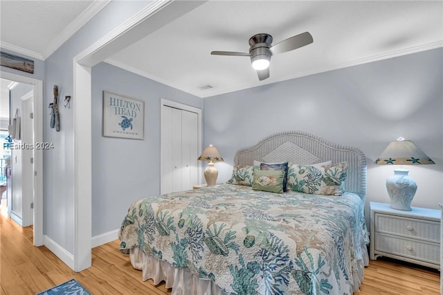 bedroom featuring hardwood / wood-style flooring, ceiling fan, crown molding, and a closet