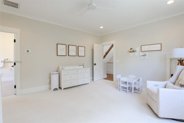 sitting room featuring ornamental molding, light colored carpet, and ceiling fan