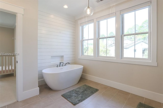 bathroom with ornamental molding, tile patterned floors, and a bath