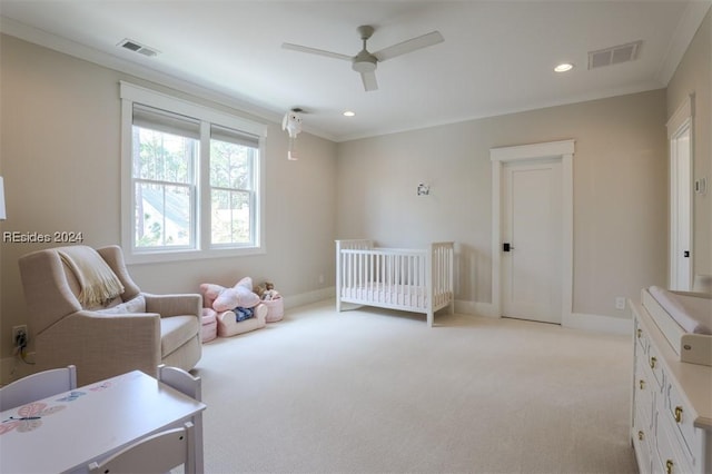 carpeted bedroom featuring crown molding, a nursery area, and ceiling fan