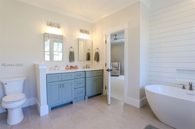 bathroom featuring tile patterned floors, a tub to relax in, toilet, and vanity