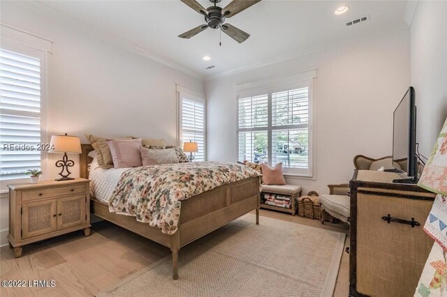 bedroom featuring ornamental molding, light wood-type flooring, and ceiling fan